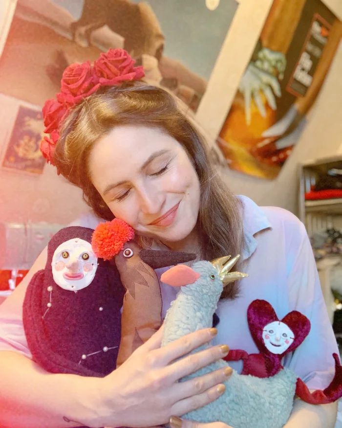 Johanna, the owner and textile artist behind Medulla Textiles, smiling as she holds two of her handmade art dolls